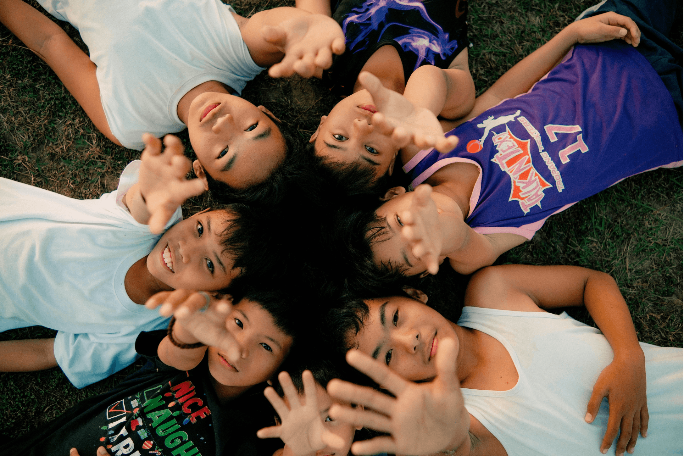 A circle of Filipino youth reaching toward the camera